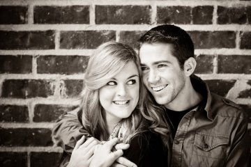 Smiling Couple Against Brick Wall